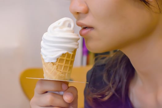 A girl eating ice cream cone white. photo