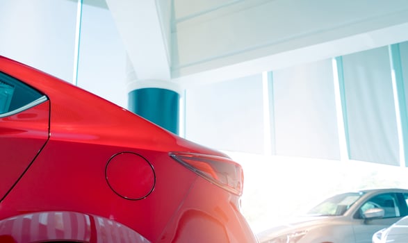 Closeup fuel tank door of red car. New and shiny luxury car parked in modern showroom for sale. Car dealership office. Electric car business concept. Automobile leasing. Automotive industry. photo