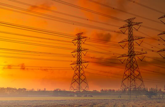 High voltage electric pylon and electrical wire with sunset sky. Electricity poles. Power and energy concept. High voltage grid tower with wire cable. Beautiful red-orange sunset sky. Infrastructure. photo
