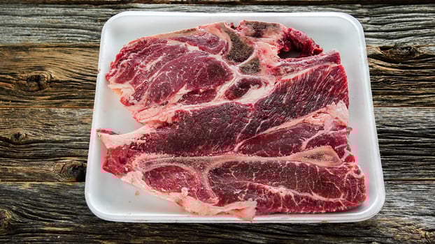 Beef chuck center cutsteak bone in on wooden rustic table photo