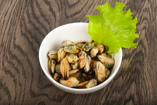 Pickled mussels in a bowl on wooden background photo