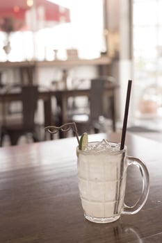 Glass of frozen lemonade with lemon slice on the wooden table photo