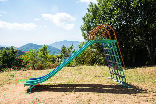 A children's playground and slider located on the sand in rural school, Thailand photo