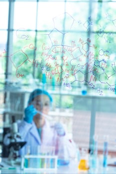 Blur Asian woman scientist, researcher, technician, or student conducted chemistry research and sitting after  glass board in laboratory photo