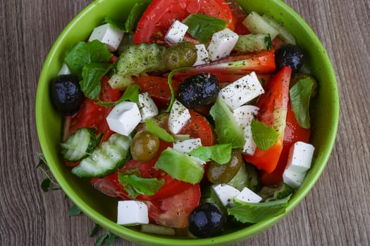Greek salad in a bowl on wooden background photo