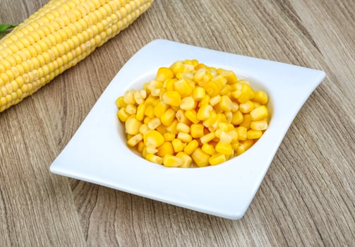 Sweet corn in a bowl on wooden background photo