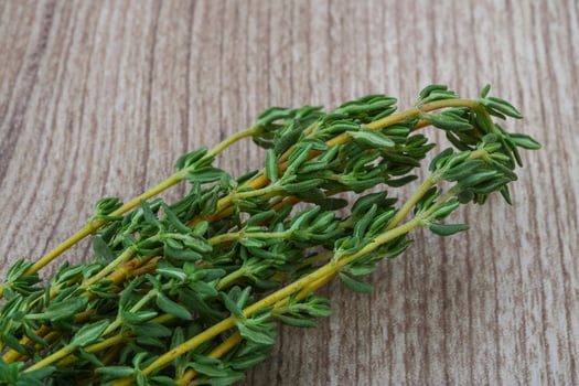 Thyme branch on wooden background photo