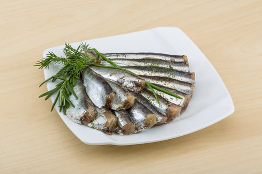 Salted anchovy in a bowl on wooden background photo