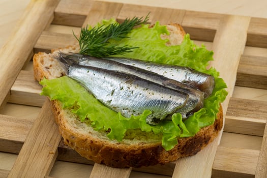 Anchovy tapas on wooden board and wooden background photo