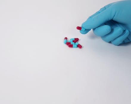 Taking or holding medication pills in hand. Capsule pill on white background. photo