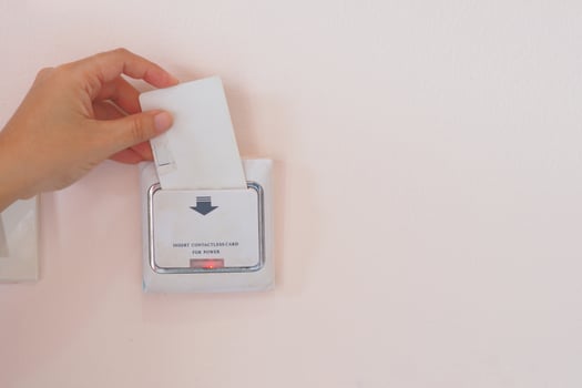 Soft Focus on Hand insert key card for on power electric equipment in the hotel room, Hotel Lock Energy Control System photo