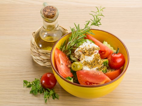 Greek salad in a bowl on wooden background photo