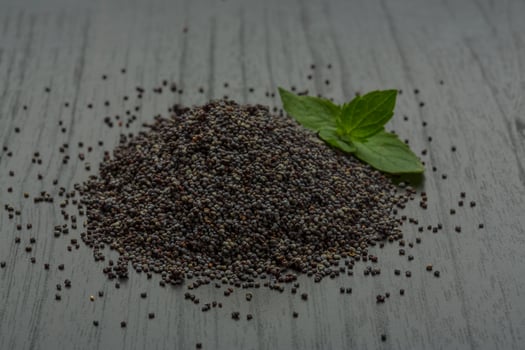 Poppy seeds on wooden background photo