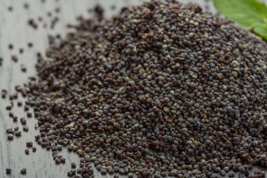 Poppy seeds on wooden background photo