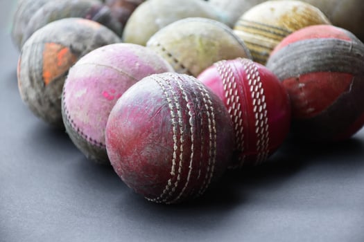 Old training cricket sport equipments on dark floor, leather ball, wickets, helmet and wooden bat, soft and selective focus, traditional cricket sport lovers around the world concept. photo