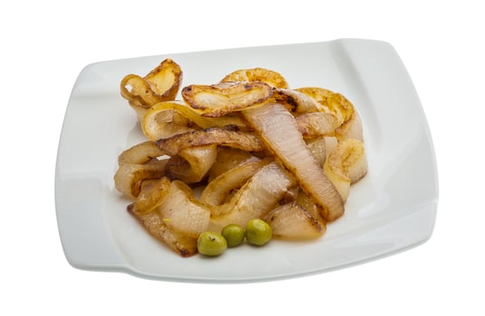 Fried onion on the plate and white background photo