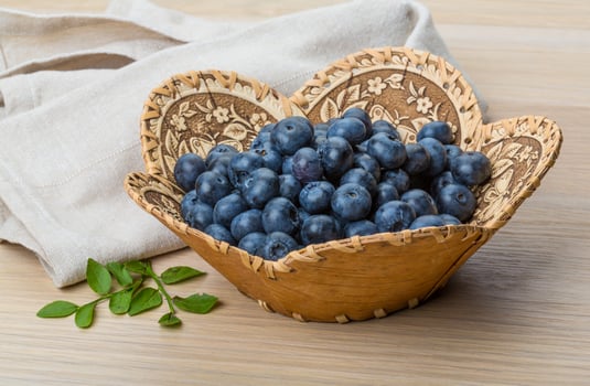 Blueberry in a basket on wooden background photo