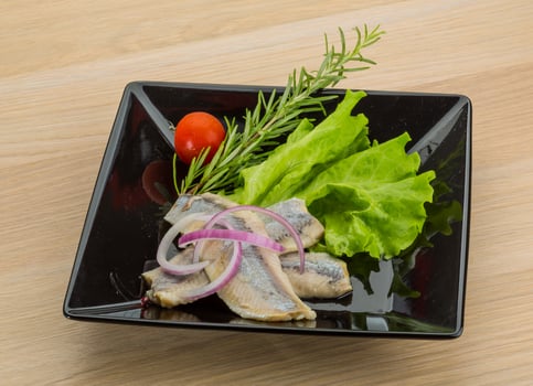 Herring fillet on the plate and wooden background photo