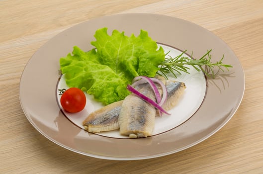 Herring fillet on the plate and wooden background photo