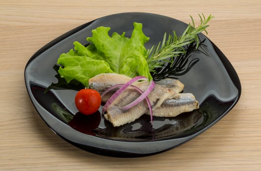 Herring fillet on the plate and wooden background photo