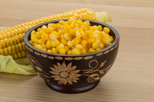 Sweet corn in a bowl on wooden background photo