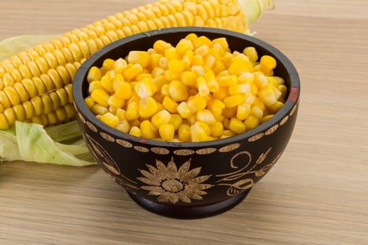 Sweet corn in a bowl on wooden background photo