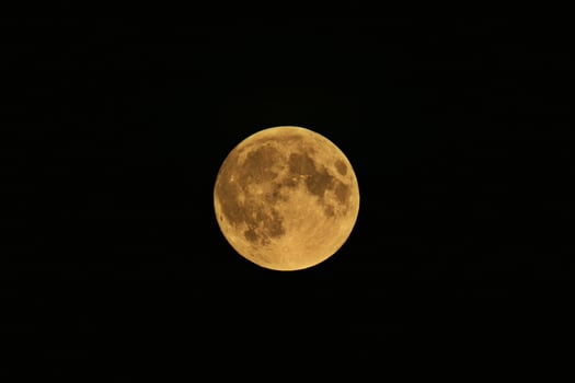 The full moon is seen in the dark sky photo