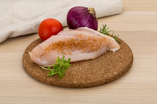 Raw chicken breast on wooden board and wooden background photo
