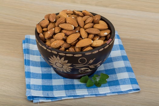 Almond in the bowl in a bowl on wooden background photo