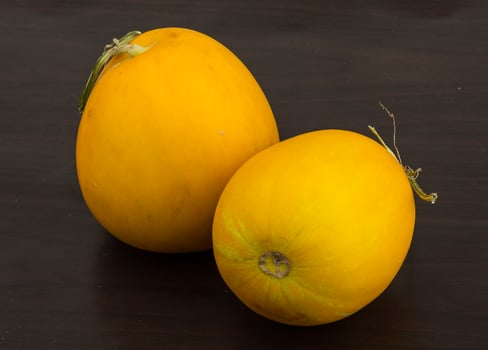 Small yellow melon on wooden background photo