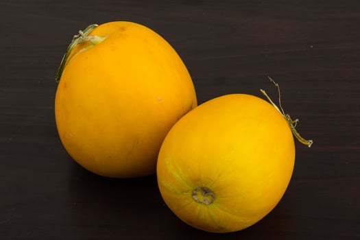Small yellow melon on wooden background photo