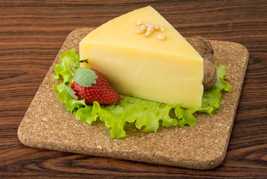 Parmesan cheese on wooden board and wooden background photo