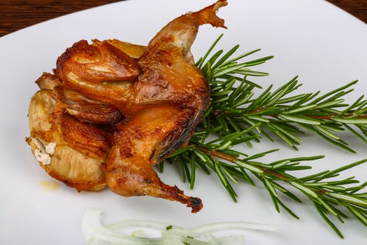 Grilled quail on the plate and wooden background photo