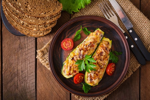 Stuffed zucchini with chicken, tomatoes and onion with cheese crust photo