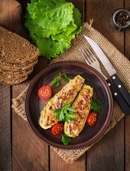 Stuffed zucchini with chicken, tomatoes and onion with cheese crust photo