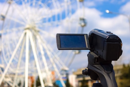 Camcorder shoots a ferris wheel in a city amusement park in the summer photo