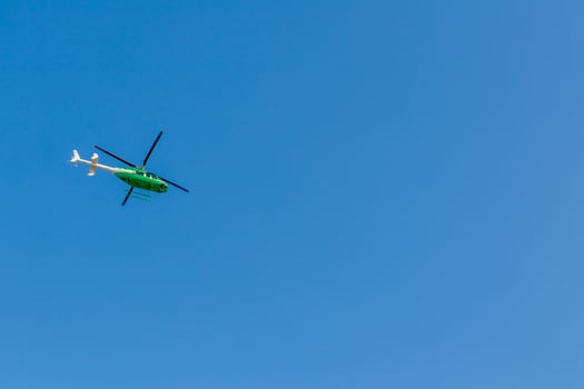 Green helicopter in the sky. photo