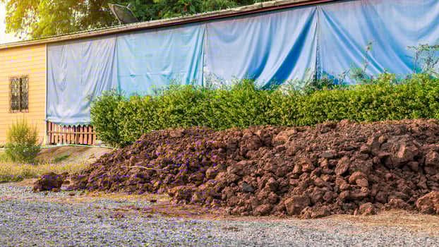 Mound of soil near the fence of the house. photo