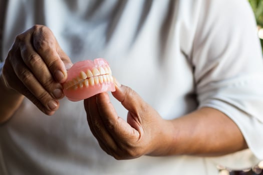 Denture in the hand of elderly women in rural Thailand. photo