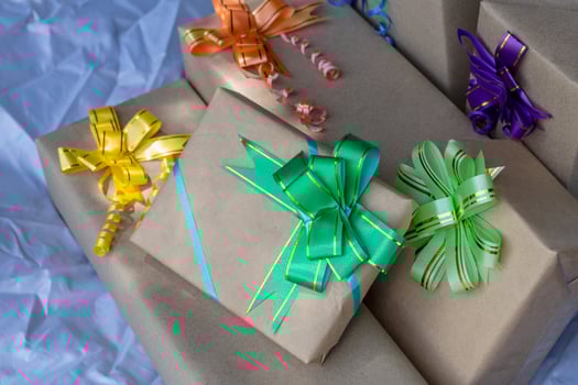 Many gift boxes tied with beautiful bows on gray canvas. photo