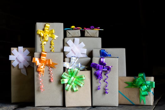 Gift paper boxes tied with numerous bows against a black backdrop. photo