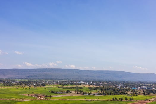 A panoramic view of the hills with villages, trees and rice fields with clouds in the sky. photo