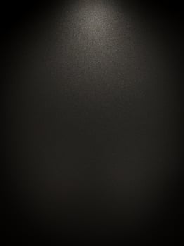 Abstract Grunge empty dark grey black wall with pattern texture grain material background with bright spotlight Rough illuminated surface shot from above. There's a vignette in the corner, copy space. photo