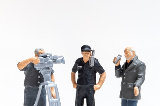 Miniature news reporter with microphone and cameraman interviewing police officers photo