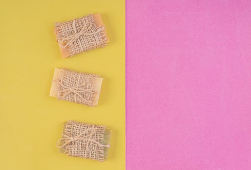 Hand made soap bars on pink-yellow background. Top view. Mockup for design photo