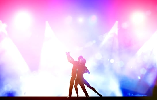A couple of dancers in elegant, passionate dancing pose in club lights photo