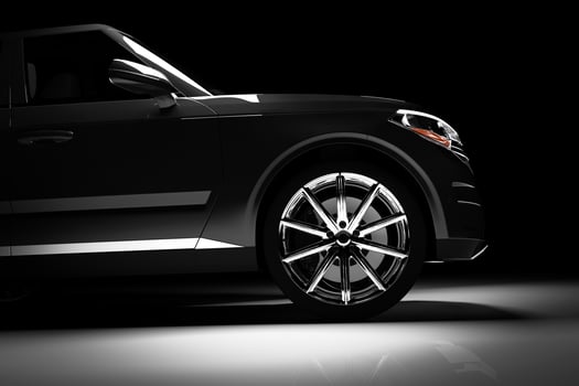 Side view of modern black SUV car in a spotlight photo