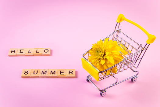 Hello summer. Shopping cart with flowers. Yellow flower on pink background. photo