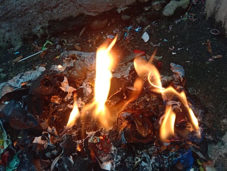 A pile of trash with flames coming out of it photo