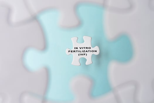 In Vitro Fertilization IVF word on puzzle pieces isolated on blue background. photo